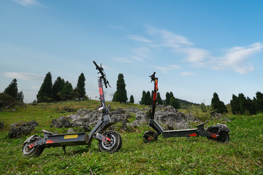 Two KuKirin electric scooters on a grassy outdoor trail
