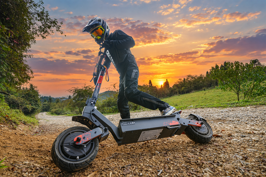 KuKirin electric scooter rider on an unpaved trail at sunset