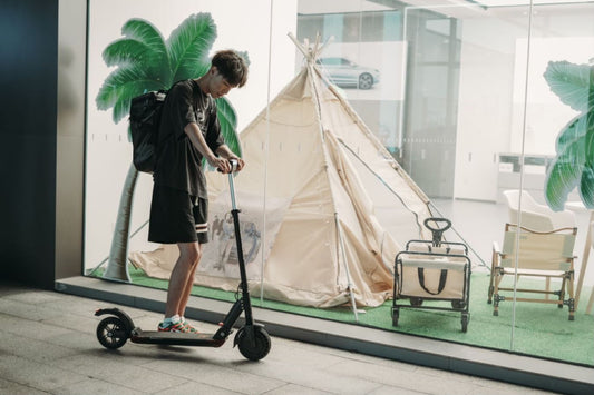 Electric scooter rider with a scooter on a city route