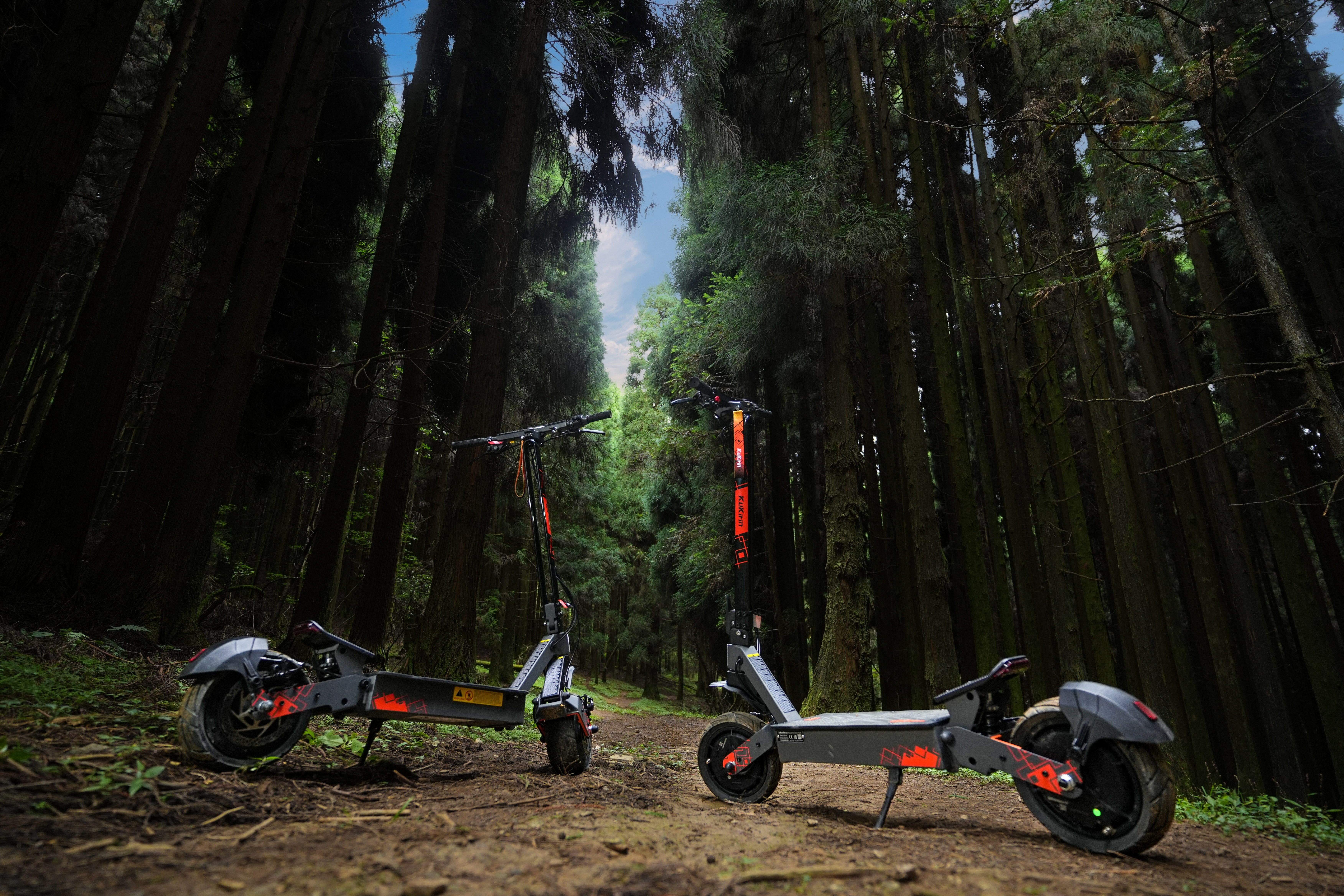 KuKirin electric scooters on a forest trail